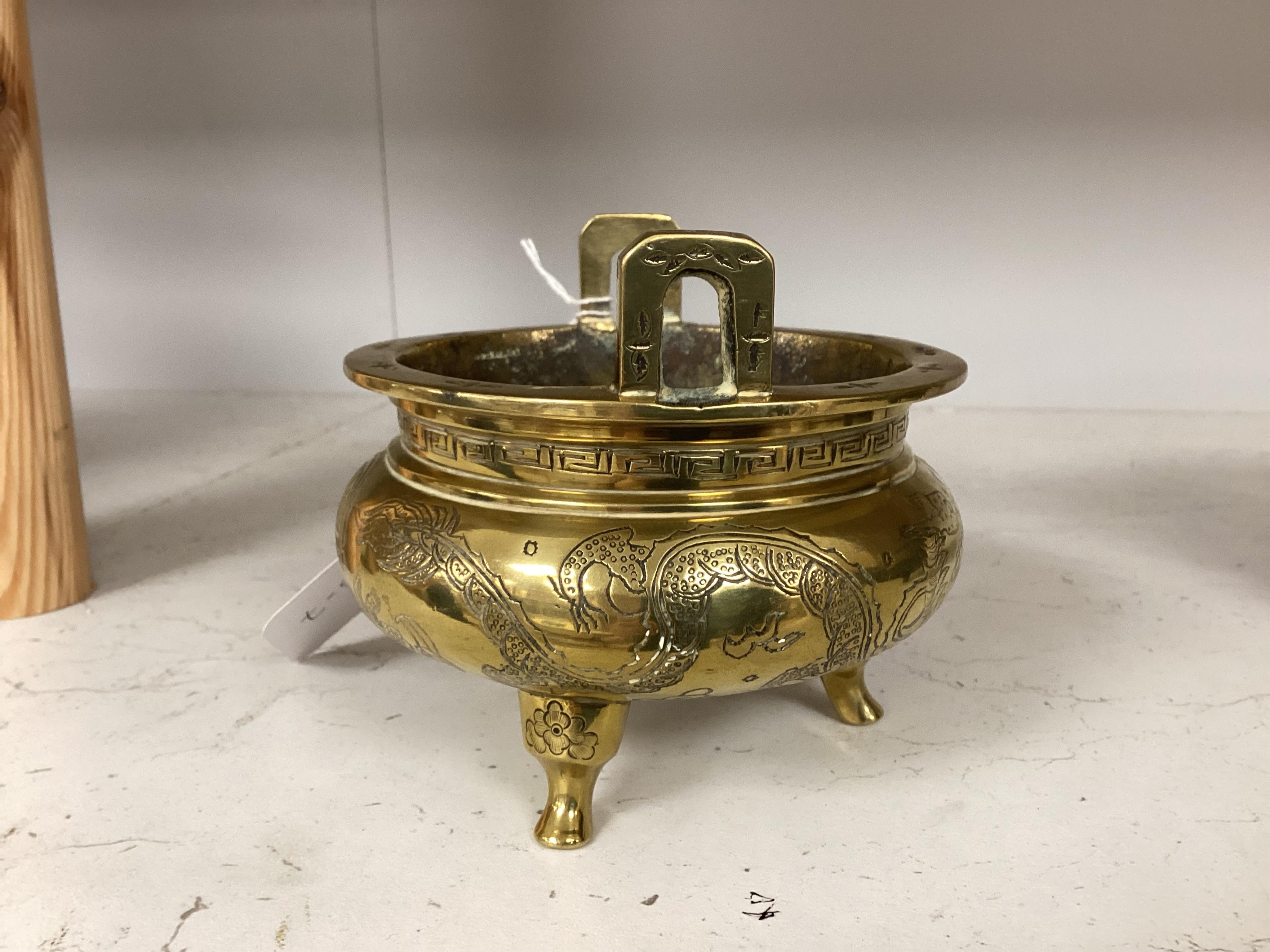 A Chinese engraved and chased bronze tripod censer, Xuande mark, early 20th century, 10.5cm. Condition - good